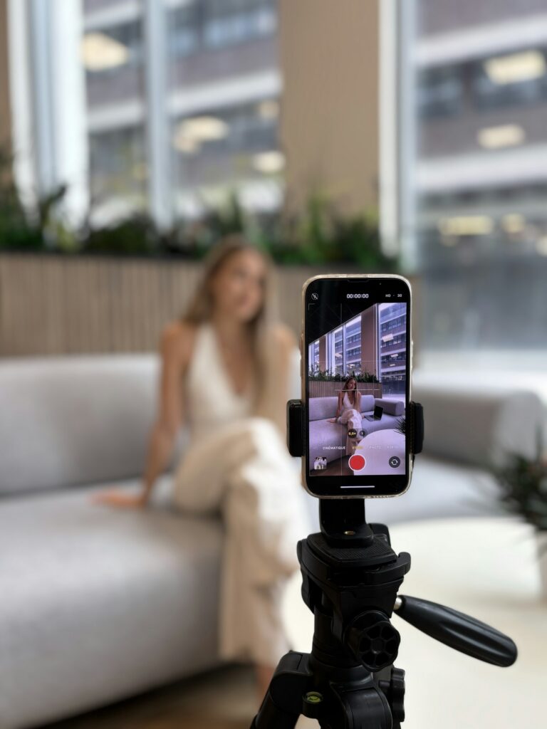 Creator recording a video of herself with a smartphone on a tripod